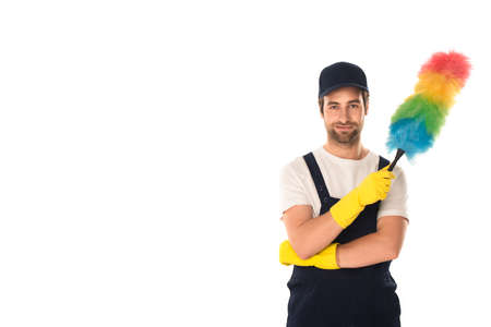 Young cleaner in cap and rubber gloves holding dust brush isolated on white