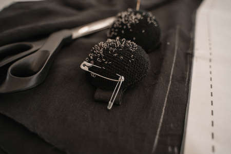 Close up view of pincushions near sewing scissors and clothの写真素材