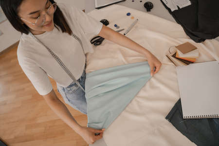 Top view of fabric in hands of asian designerの写真素材