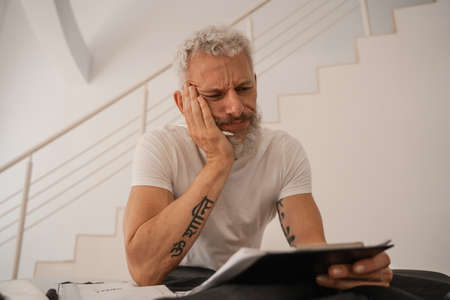 Sad designer looking at clipboard in studio