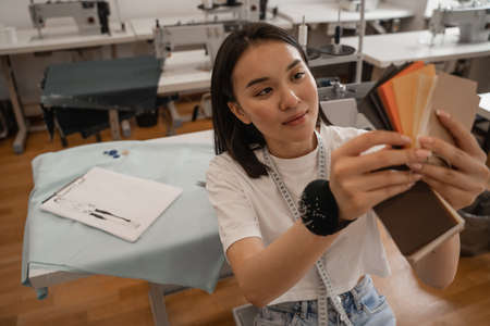 Asian designer holding blurred color swatches in atelierの写真素材