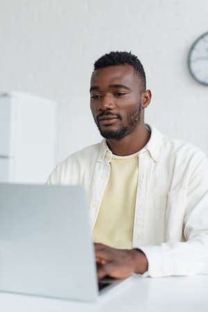 young african american man using blurred laptopの写真素材
