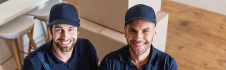happy handymen in caps looking at camera, bannerの写真素材