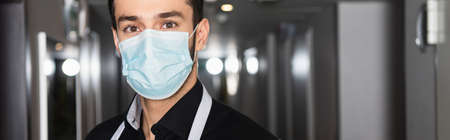 housekeeper in medical mask looking at camera, bannerの写真素材