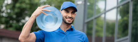 Positive muslim courier with bottle of water outdoors, bannerの写真素材
