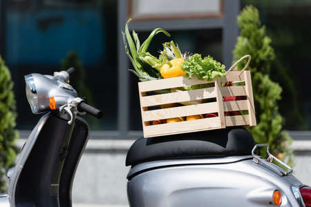 Wooden box with fresh vegetables on scooter outdoorsの写真素材