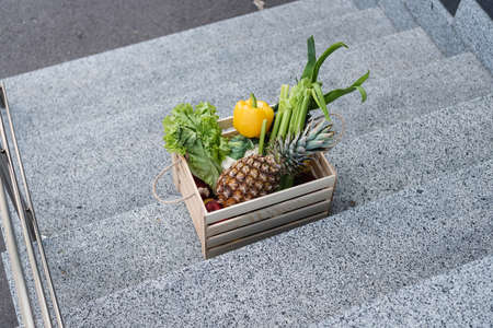 High angle view of fresh vegetables and pineapple on stairs outdoorsの写真素材