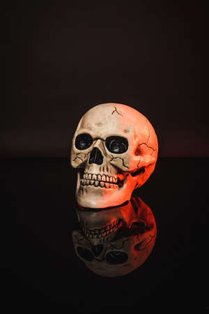 red lighting on aged and creepy skull on blackの写真素材