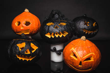 carved and spooky pumpkins on black backgroundの写真素材