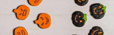 top view of sweet and spooky pumpkin shape halloween cookies on white surface, bannerの写真素材