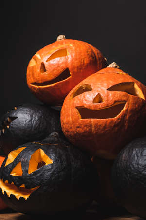 stack of carved and creepy pumpkins isolated on blackの写真素材