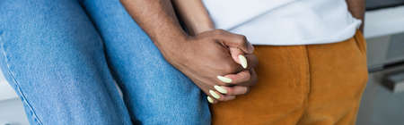 Cropped view of african american couple holding hands, bannerの写真素材