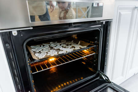 baking sheet with multi shaped cookies in electric ovenの写真素材