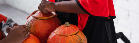 partial view of african american kids carving pumpkins, bannerの写真素材