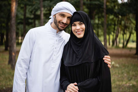 Muslim couple in traditional clothes smiling at camera outdoorsの写真素材
