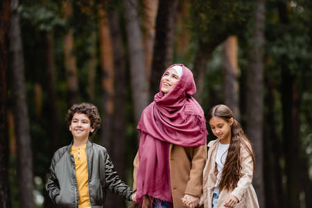 Muslim woman smiling near kids outdoorsの写真素材