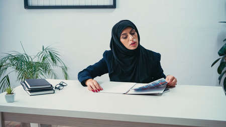 Muslim businesswoman in hijab working with papers in officeの写真素材