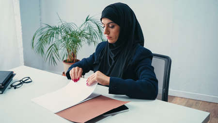 Muslim businesswoman in hijab working with documents in officeの写真素材