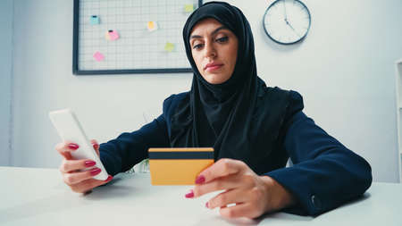Muslim businesswoman using smartphone and credit cardの写真素材