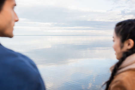 Sea and blurred interracial couple on foregroundの写真素材