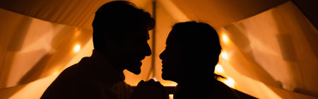 Side view of silhouettes of couple in glamping house, bannerの写真素材
