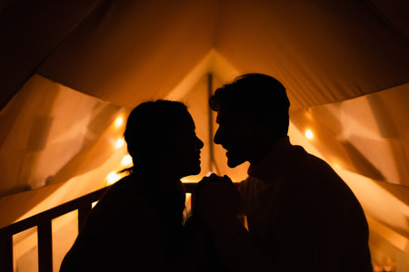 Side view of silhouette of couple in glamping house