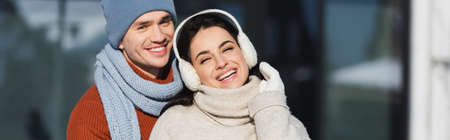 happy young couple in winter outfit smiling outside, bannerの写真素材