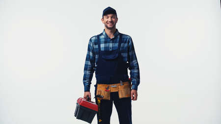 Smiling workman with tool belt and box looking at camera isolated on whiteの写真素材