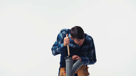 Plumber cleaning plastic pipe with plunger isolated on whiteの写真素材
