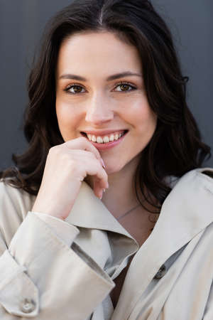 close up portrait of happy brunette woman smiling at camera outdoorsの写真素材