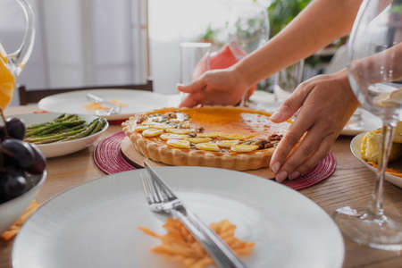 Cropped view of african american woman putting tasty pie on table near thanksgiving dinner
