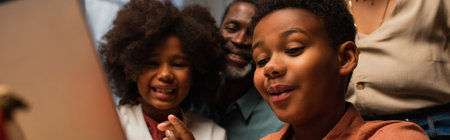 excited african american kids near blurred laptop during video call on thanksgiving day, bannerの写真素材