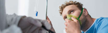patient in oxygen mask looking at blurred doctor, bannerの写真素材