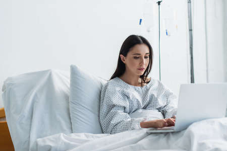 freelancer using laptop while working remotely in hospitalの写真素材