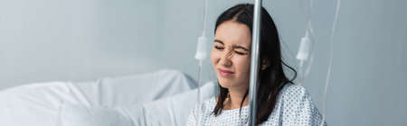 sick woman with closed eyes feeling pain during therapy in hospital, bannerの写真素材