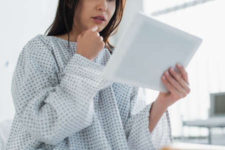 cropped view of brunette patient using digital tablet in clinicの写真素材