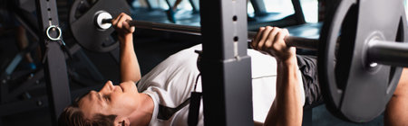 athletic man working out on weightlifting exercising machine, banner