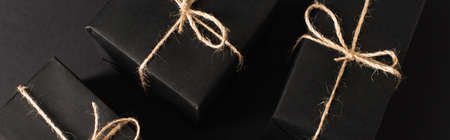 top view of wrapped dark gift boxes on black, banner