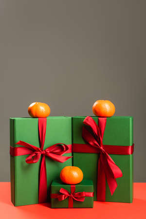 tangerines on green wrapped presents isolated on greyの写真素材
