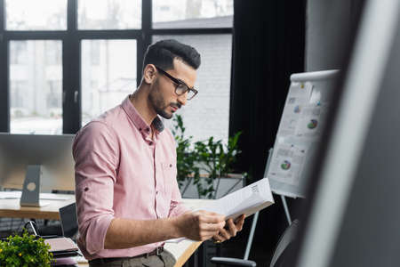 Arabian manager working with documents in paper folder in officeの写真素材