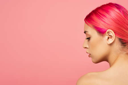 profile of pretty young woman with colorful hair and bare shoulder isolated on pinkの写真素材