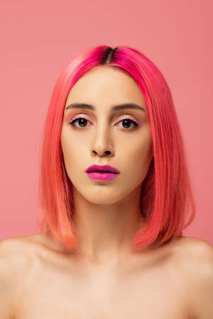 young woman with colorful hair and bright makeup isolated on pinkの写真素材