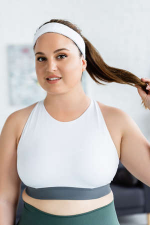 Young plus size sportswoman looking at camera at home