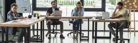 Multiethnic business people working with documents and laptops in office, banner