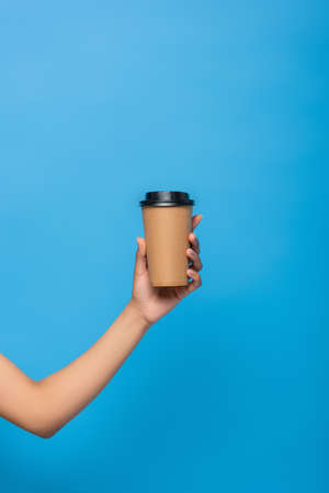 cropped view of african american woman holding takeaway drink isolated on blueの写真素材