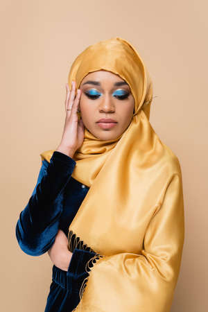 muslim woman in hijab with bright eye shadow isolated on beigeの写真素材