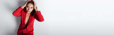 top view of trendy woman in red suit posing on grey, banner