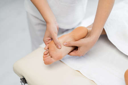 high angle view of masseur doing foot massage to client in spa centerの写真素材