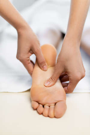 cropped view of masseur doing foot massage to clientの写真素材