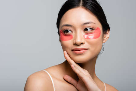 Portrait of young asian woman in eye patches isolated on greyの写真素材